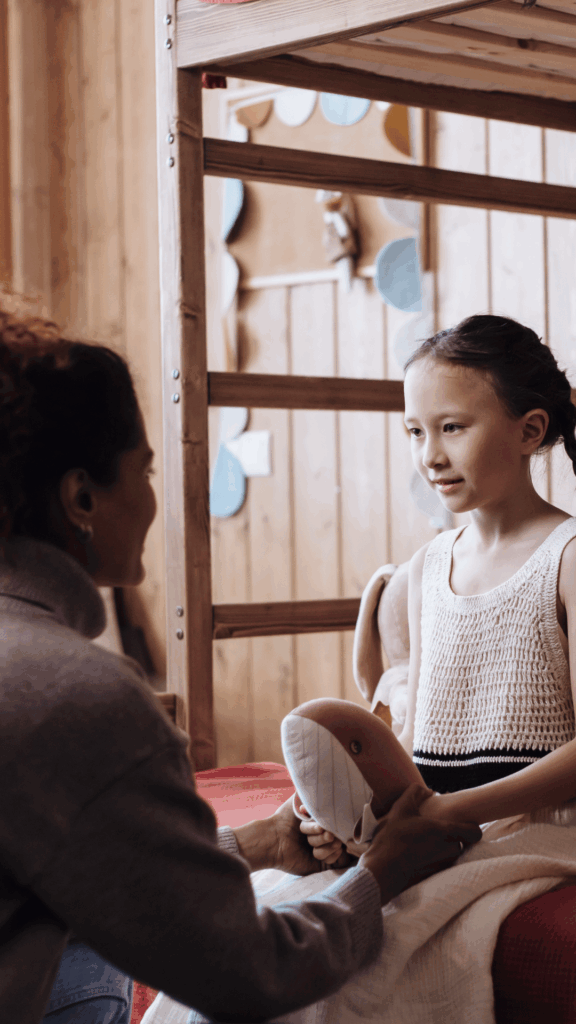Mother talking gently with daughter, modeling repair and connection after conflict in a parenting moment